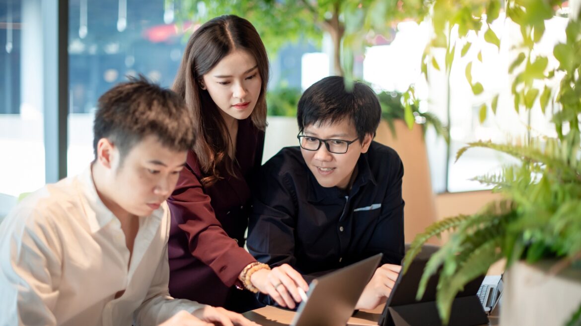 Three person discussing in a laptop